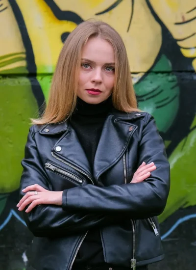 Young blonde woman next to graffiti wall. Street art and contemporary painting process. Street lifes